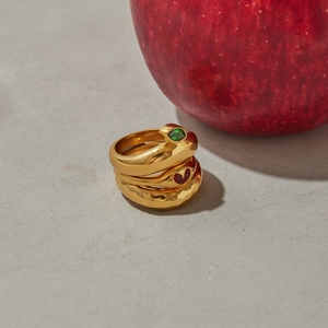 Detailed view of three-piece gold-plated stackable rings with snake and heart enamel motifs