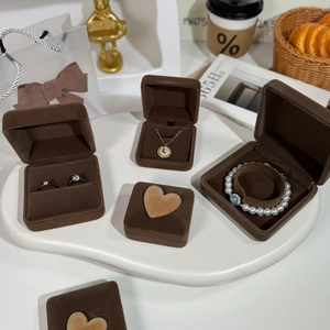 Detailed texture of brown velvet jewelry box set on white tray with soft lighting