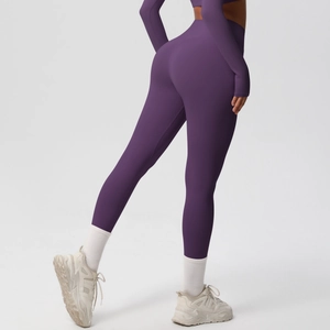 Detail view showing rear fit of dark purple high-waisted yoga leggings and long sleeve top