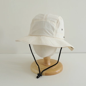 Detail of cream quick-dry kids sun hat showing breathable metal eyelets and adjustable cord