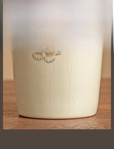 Detail of crackle glaze ceramic cup with hand-painted cat paw and anti-slip bottom