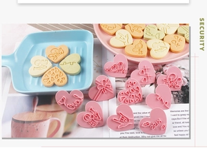 Detail view of heart-shaped LOVE cookie cutters with 3D embossed plastic stamps