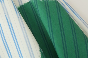 Close-up of striped fabric texture showing blue and white lines with green color blocks
