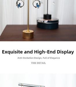 Close-up of golden metal earring display stand featuring blue cat charms and floral details