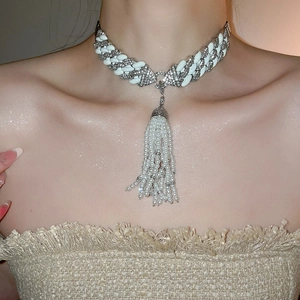 Detail of zircon chain necklace with pearl tassel and crystal-encrusted metal links