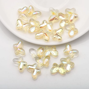 Close-up of champagne iridescent butterfly glass beads on a white ceramic tray for DIY