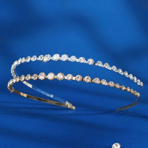 Macro shot of silver and gold metal headbands with sparkling rhinestones on blue silk
