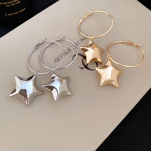 Orecchini a cerchio con pendenti a stella lucidi in oro e argento su cartoncino