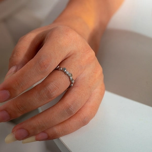 Detailed view of silver stainless steel ring with hollow geometric leaf pattern on finger