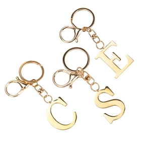 Golden stainless steel letter E S C keychains with lobster clasp and round ring on white background