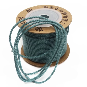 Detail of 1.5mm teal woven cotton cord on a spool for DIY jewelry and beaded crafts