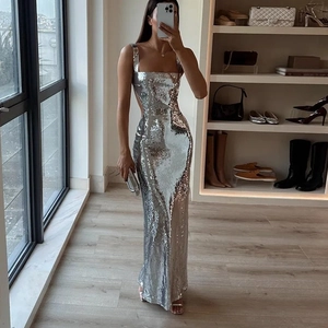 Close-up of shimmering silver sequins on a slim-fit backless evening maxi dress