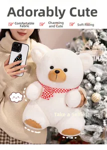 Close-up of white plush teddy bear with red plaid scarf in a cozy Christmas setting