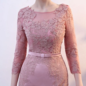 Detail of dusty pink lace dress with floral textures and satin belt with a small bow