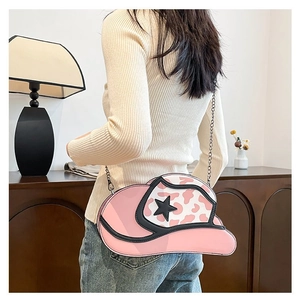 Detail view of pink cowboy hat-shaped shoulder bag with star pattern and chain strap