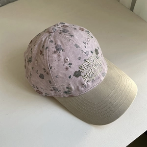 Gros plan de la broderie Sunday Morning sur une casquette de baseball à fleurs bicolore
