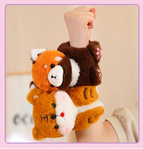 Close-up of cute plush animal snap bracelets worn on a wrist, featuring tiger and panda designs.