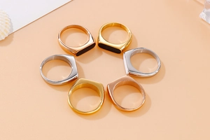 Detailed macro view of retro stainless steel rings in gold, rose gold and silver finishes