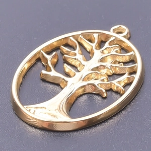 Macro view of polished 18k gold-plated oval tree of life pendant with镂空 detail
