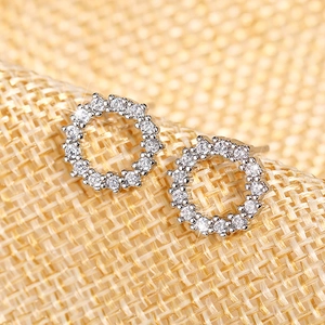Macro shot of silver circular stud earrings with pavé set white cubic zirconia stones