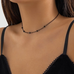 Close-up of minimalist gothic choker with faceted black beads on a thin chain for women