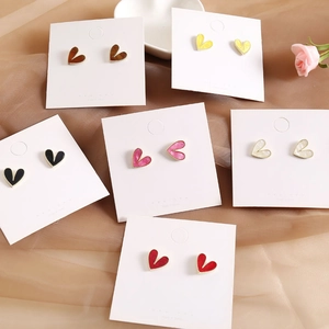 Elegant set of heart-shaped S925 silver stud earrings in various colors on satin fabric