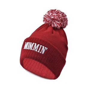 Detailed close-up of dark red knitted beanie with MOMMIN embroidery and pom-pom topper