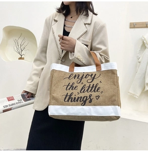 Close-up of khaki linen tote bag with brown handles and enjoy the little things print