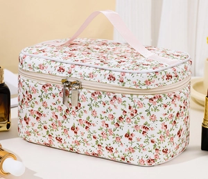 Close-up of pink floral toiletry bag with zipper detail and soft pink top handle