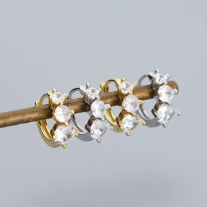 Macro shot of 925 sterling silver hoop earrings with three sparkling round zircons