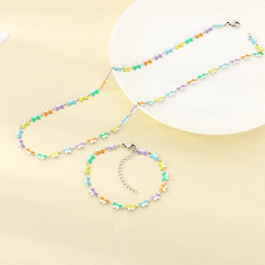 Detalle de conjunto de collar y pulsera de mariposa en esmalte de colores y plata