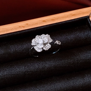 Macro shot of silver flower open ring with sparkling white zircon pavé on black velvet
