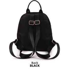 Detail view of the black backpack back with adjustable straps and gold metal buckles