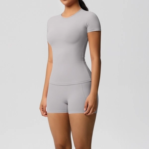 Detail shot of grey two-piece compression yoga set featuring short sleeve top and shorts