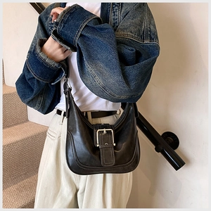 Detailansicht der schwarzen Vintage-Ledertasche mit Silberschnalle und Ziernaht-Struktur
