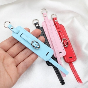 Detail view of colorful PU leather wristband keychains with silver buckles and white stitching