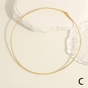 Detail of 18K gold-plated snake bone chain on a textured white background