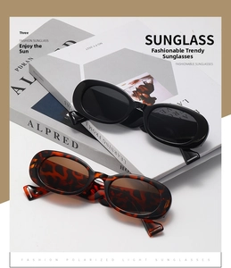 Detail view of oval polarized sunglasses with black and tortoiseshell frames on a book