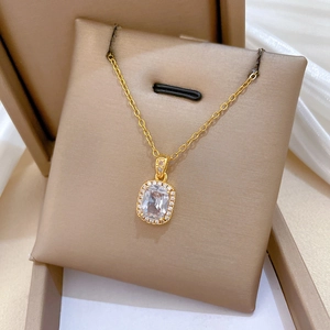 Close-up of gold cubic zirconia square pendant necklace displayed in a premium brown gift box