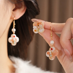 Macro shot of vintage palace style flower earrings with pearls and colorful zircons