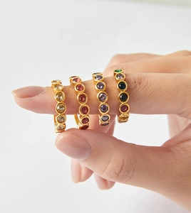 Dettaglio di anelli placcati oro 18K con zirconi colorati per un look elegante