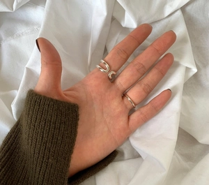 Close-up of dual layer H-shaped open sterling silver rings worn on model fingers