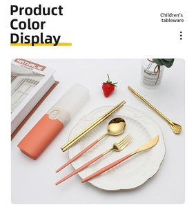 Detail of gold stainless steel cutlery set with coral orange handles in a storage case