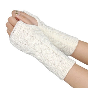 Close-up of beige cable knit fingerless gloves showing detailed acrylic yarn texture