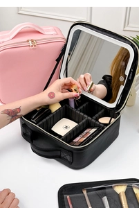 Detail of portable makeup case with LED mirror showing multi-compartment storage space