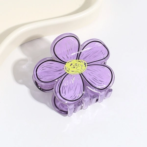 Detailed close-up of purple flower claw clip with yellow center and black outlines