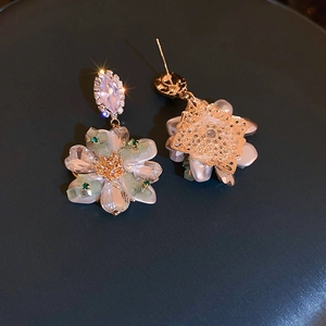 Detailed view of woven crystal flower earrings with gold finish and zircon accents