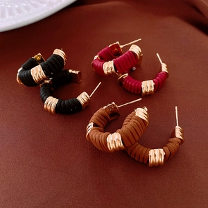 Detail of vintage faux leather wrapped C-shape hoop earrings in black, red and brown colors