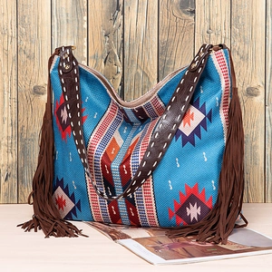 Detail of bohemian tote showing tribal patterns and brown leather straps with white stitching