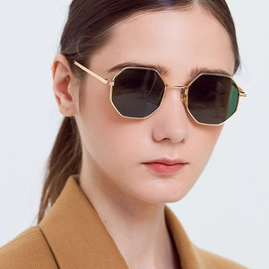 Close-up of gold octagonal metal frame sunglasses with dark lenses on a male model